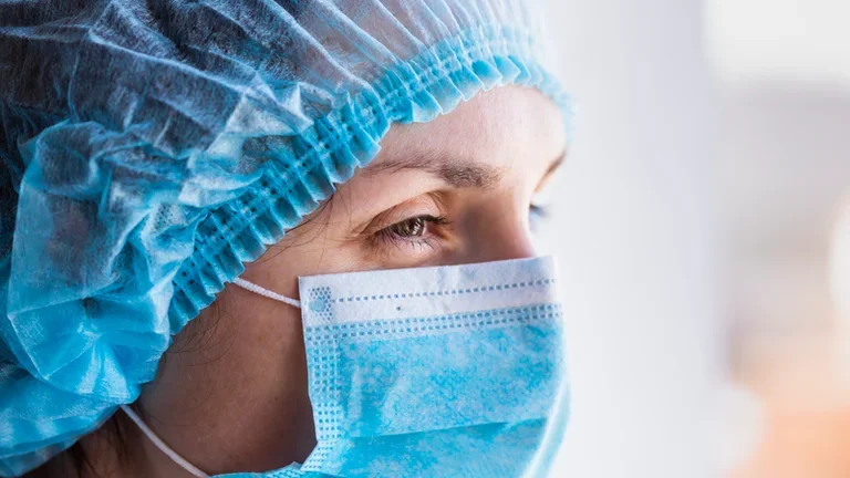 Portrait of a doctor woman in a medical mask and a protective cap
